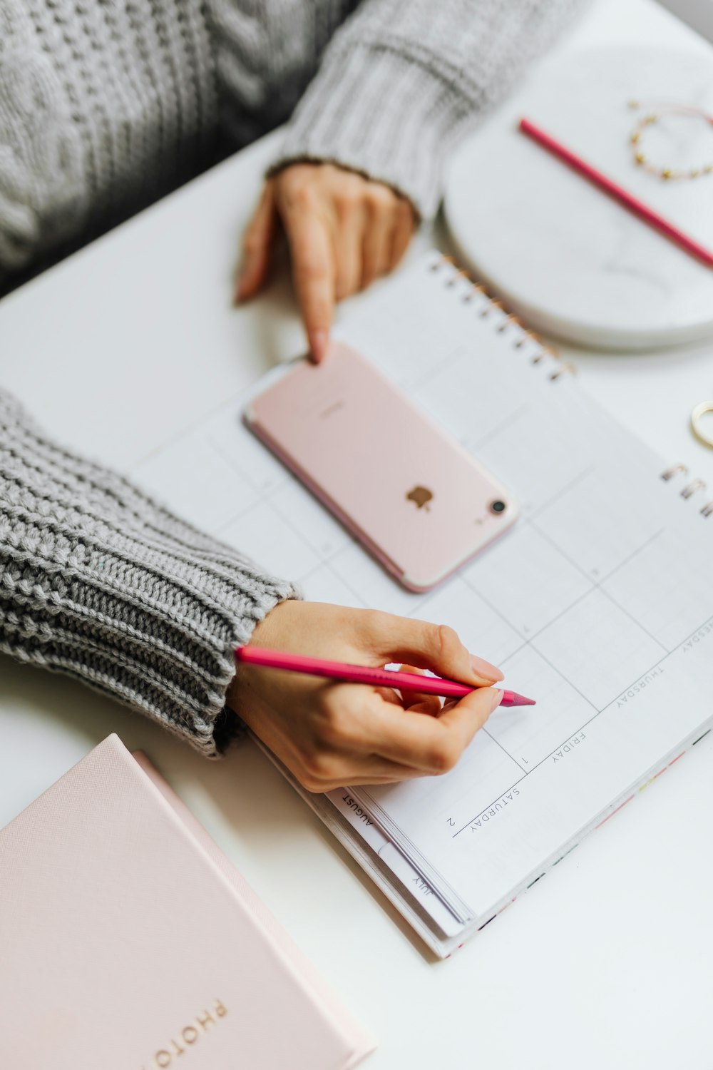 A planner and phone on a desk